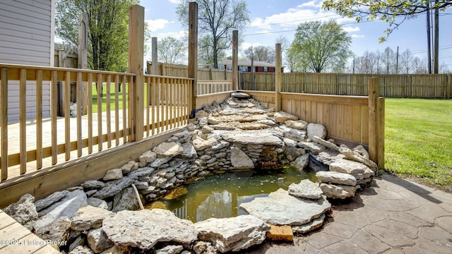 view of yard with a fenced backyard and a small pond
