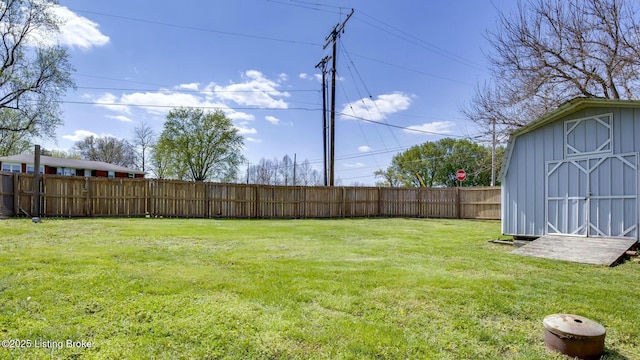 view of yard featuring an outbuilding, a shed, and a fenced backyard