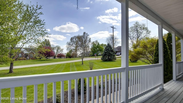 wooden terrace with a porch and a yard