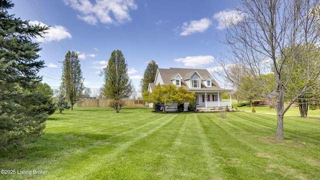 view of yard featuring a porch and fence