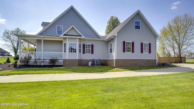 view of front of home featuring central air condition unit, a front lawn, fence, and covered porch