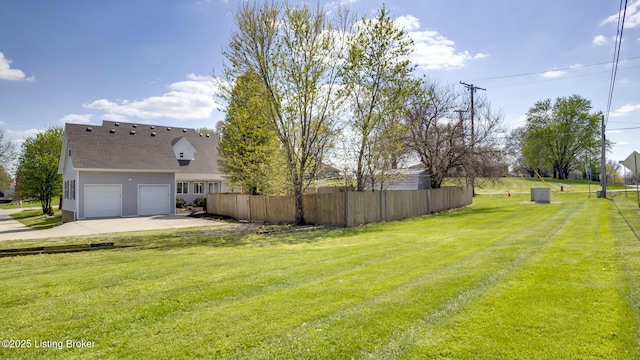 view of yard featuring fence and driveway