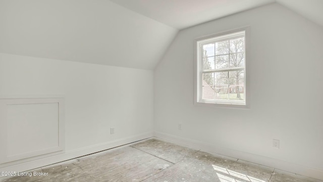 bonus room featuring lofted ceiling and baseboards