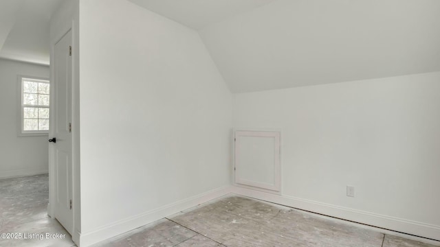 additional living space featuring lofted ceiling and baseboards