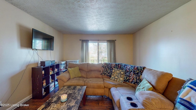 living room featuring a textured ceiling, baseboards, and dark wood finished floors