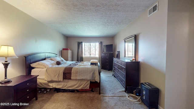 carpeted bedroom featuring a textured ceiling and visible vents