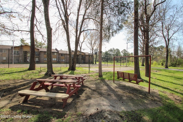 view of property's community featuring a yard and fence