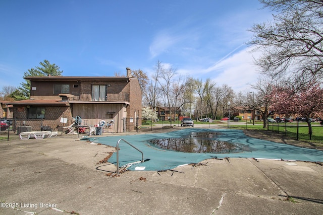 pool with a patio area and fence