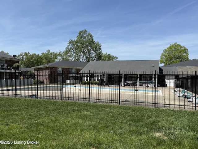 pool featuring fence and a yard