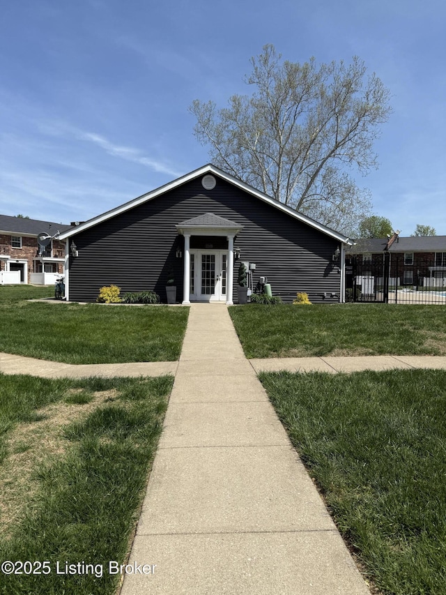 view of front facade with french doors, fence, and a front yard