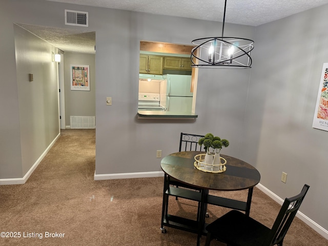 dining area with carpet flooring, a textured ceiling, visible vents, and baseboards