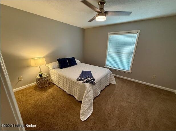 carpeted bedroom featuring baseboards and ceiling fan