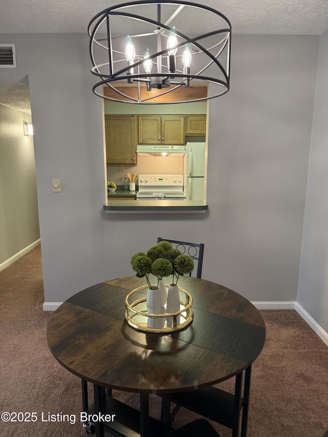 carpeted dining area featuring visible vents, a textured ceiling, baseboards, and a chandelier