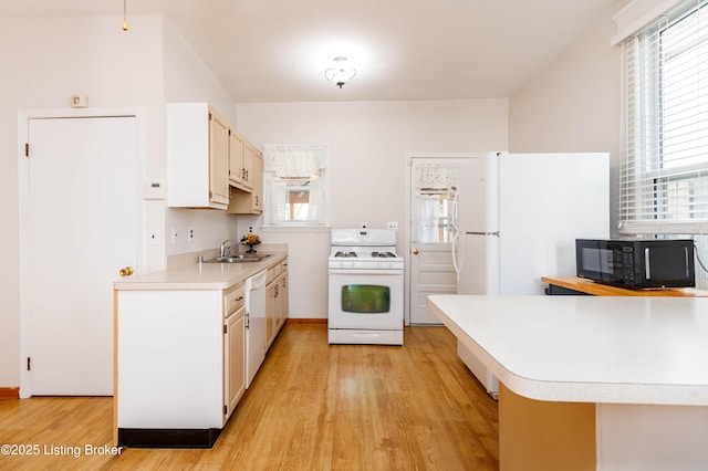 1035 Lydia St, Louisville, KY 40217 - kitchen featuring white appliances, a sink, light countertops, light wood finished floors, and white cabinets