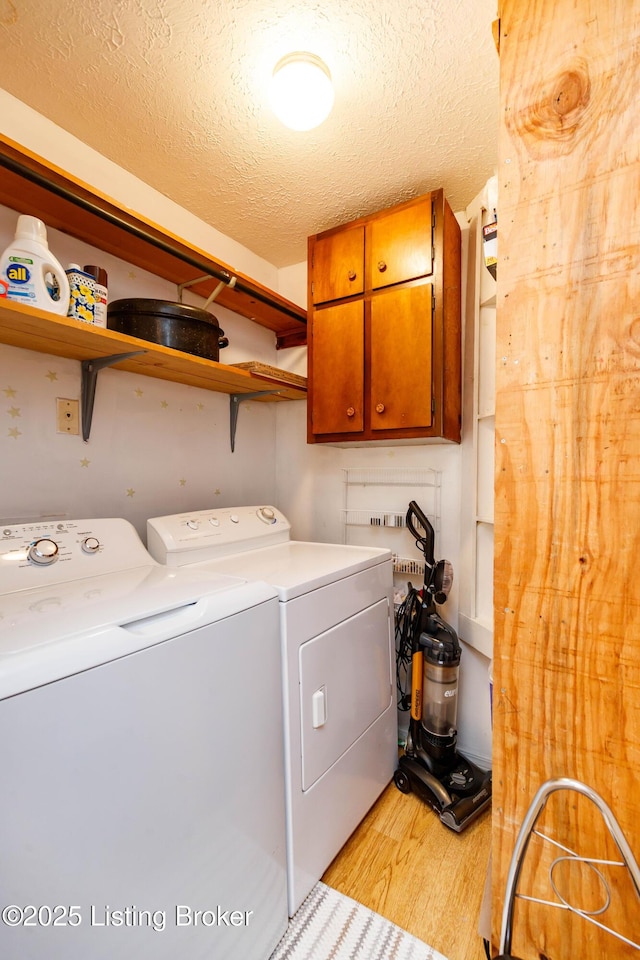 1035 Lydia St, Louisville, KY 40217 - washroom featuring cabinet space, light wood-style floors, washing machine and clothes dryer, and a textured ceiling