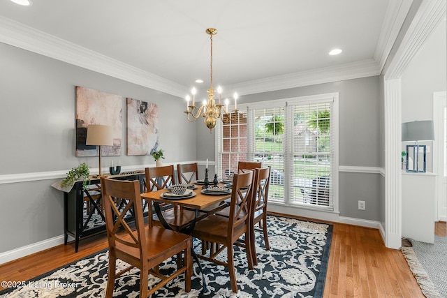 dining space with a chandelier, baseboards, recessed lighting, ornamental molding, and wood finished floors