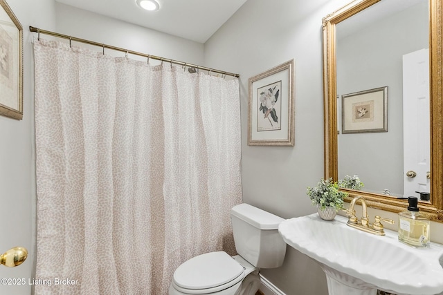 full bathroom with toilet, a shower with curtain, and a sink