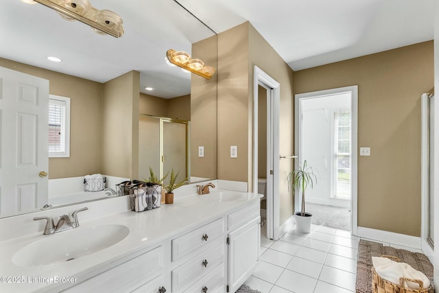 full bathroom featuring tile patterned floors, baseboards, a stall shower, and a sink