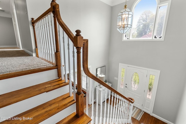interior space featuring visible vents, baseboards, an inviting chandelier, ornamental molding, and wood finished floors