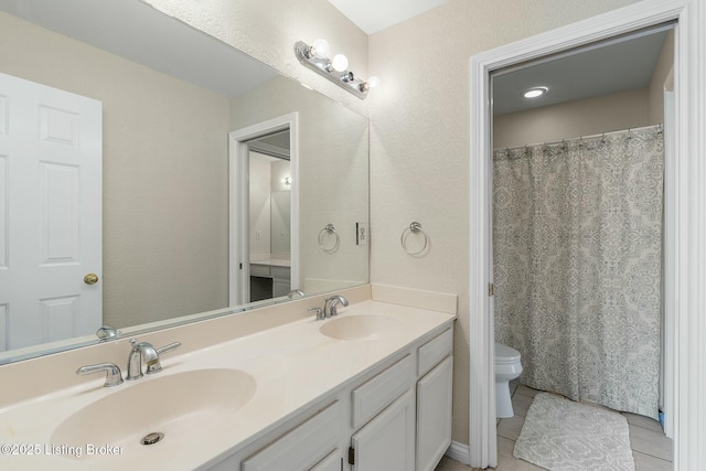 full bath with toilet, double vanity, a sink, and tile patterned floors