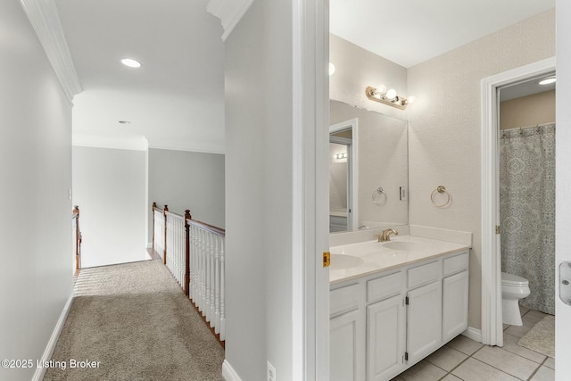 full bathroom featuring a sink, toilet, double vanity, baseboards, and ornamental molding