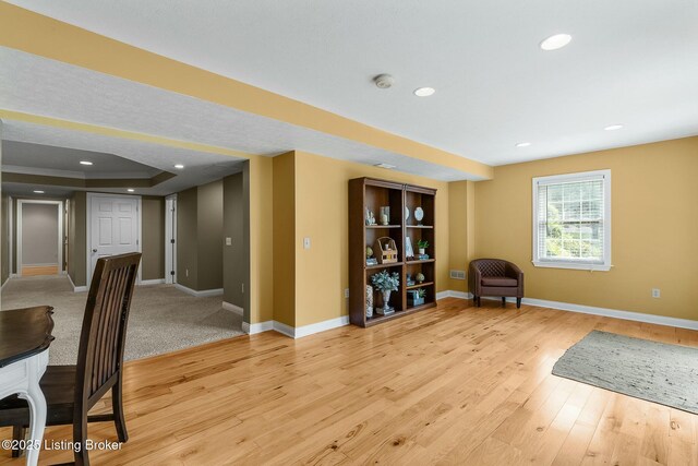 living area with baseboards, recessed lighting, and light wood-style flooring