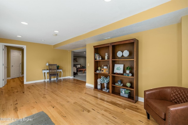 sitting room with baseboards, recessed lighting, and light wood-style flooring