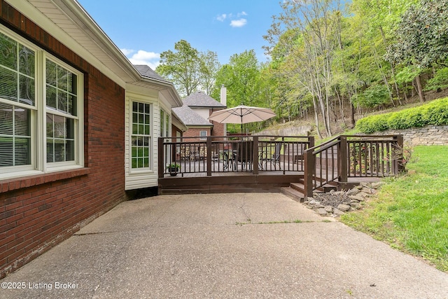view of gate featuring a patio and a wooden deck