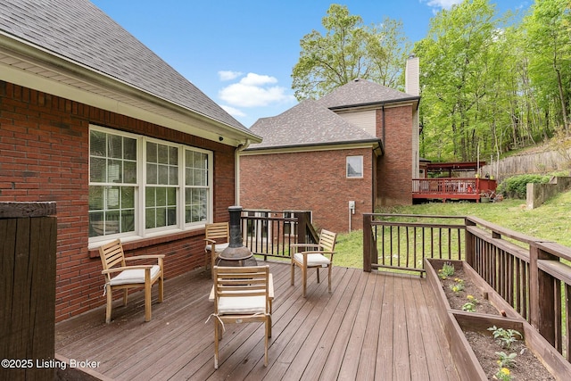 wooden terrace featuring a lawn