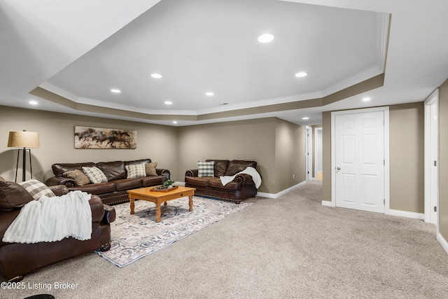 living area with ornamental molding, carpet flooring, and a tray ceiling