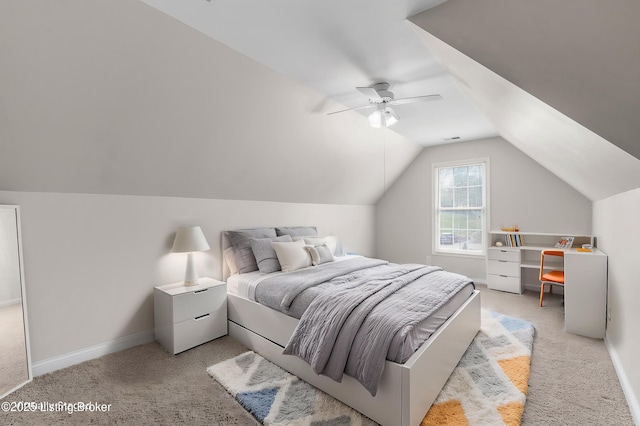 bedroom featuring light colored carpet, visible vents, baseboards, vaulted ceiling, and a ceiling fan
