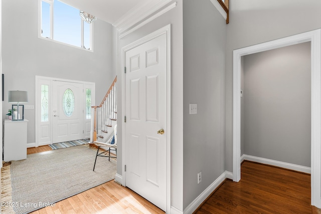 foyer entrance featuring baseboards, wood finished floors, and a healthy amount of sunlight