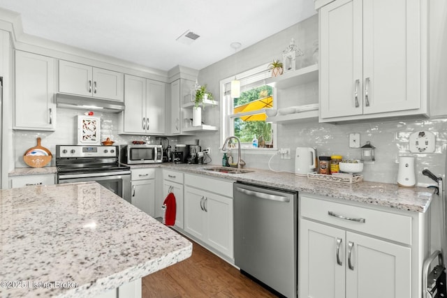kitchen featuring a sink, under cabinet range hood, decorative backsplash, open shelves, and appliances with stainless steel finishes