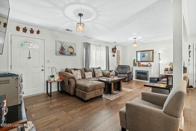 living area with visible vents, wood finished floors, and a wealth of natural light