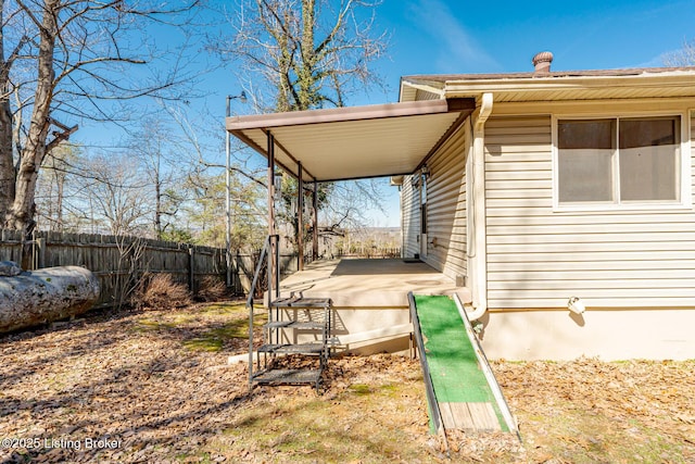 exterior space featuring a carport and fence