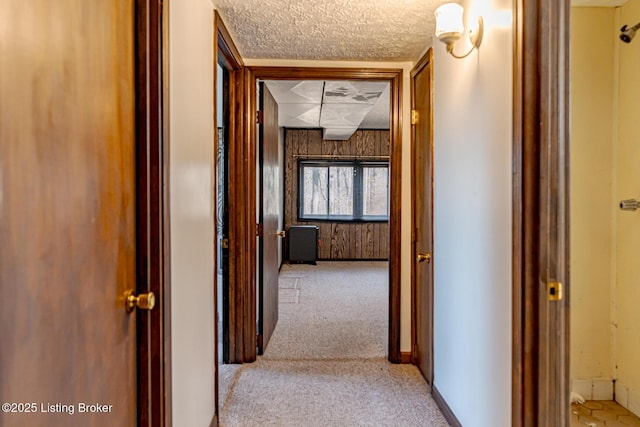 hall with carpet flooring and a textured ceiling