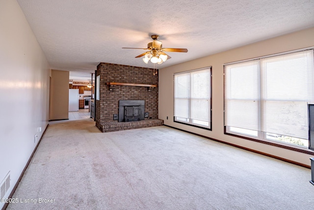 unfurnished living room with baseboards, light colored carpet, a textured ceiling, and ceiling fan