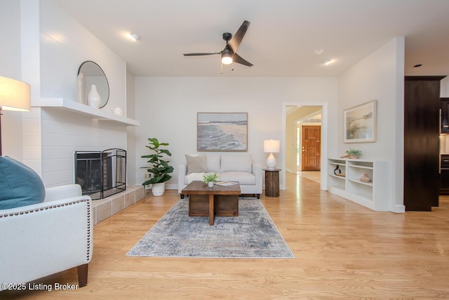 1038 Garden Creek Cir, Louisville, KY 40223 - living area featuring a ceiling fan, light wood-style floors, a fireplace, and baseboards