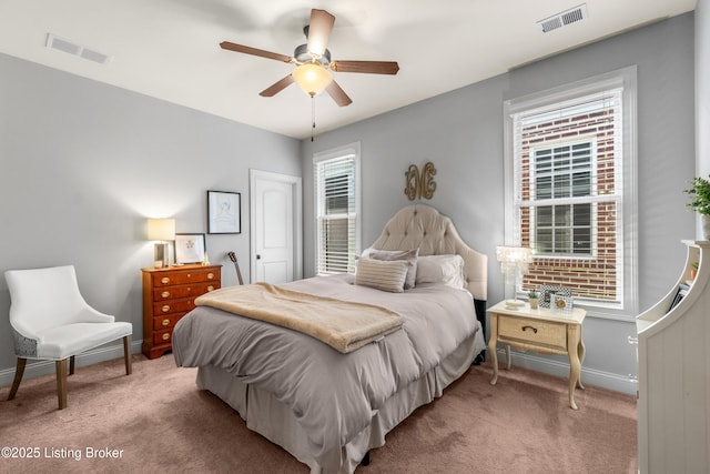 bedroom featuring baseboards, visible vents, light carpet, and multiple windows