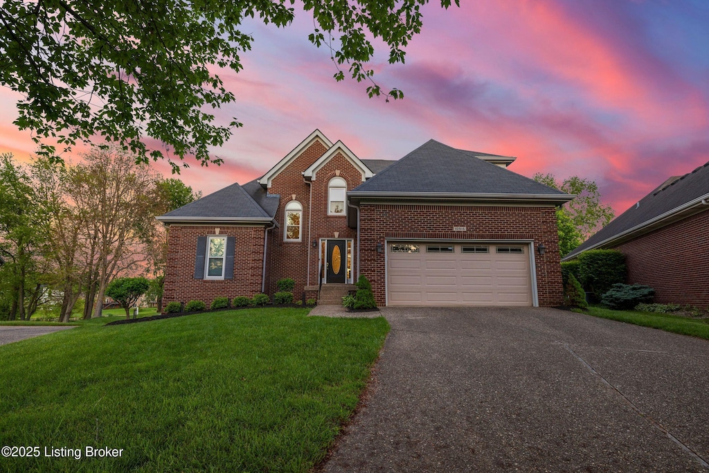 10916 Lake Vista Ct, Louisville, KY 40241 - traditional home with driveway, brick siding, a yard, and a garage