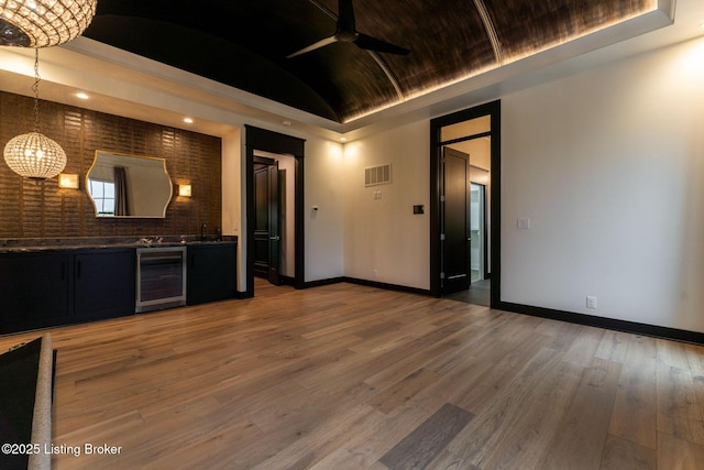 11004 Meeting St, Prospect, KY 40059 - unfurnished living room featuring wine cooler, baseboards, a chandelier, ceiling fan, and lofted ceiling