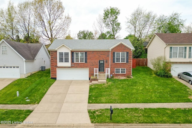 raised ranch featuring concrete driveway, an attached garage, fence, brick siding, and a front lawn