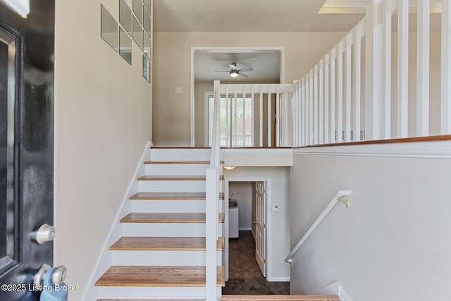 staircase with ceiling fan and washer / clothes dryer