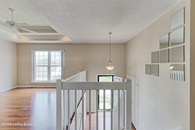 foyer with a textured ceiling, a ceiling fan, wood finished floors, and baseboards