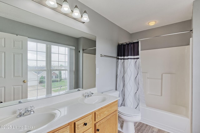 full bathroom with shower / bath combo, a sink, toilet, double vanity, and wood finished floors