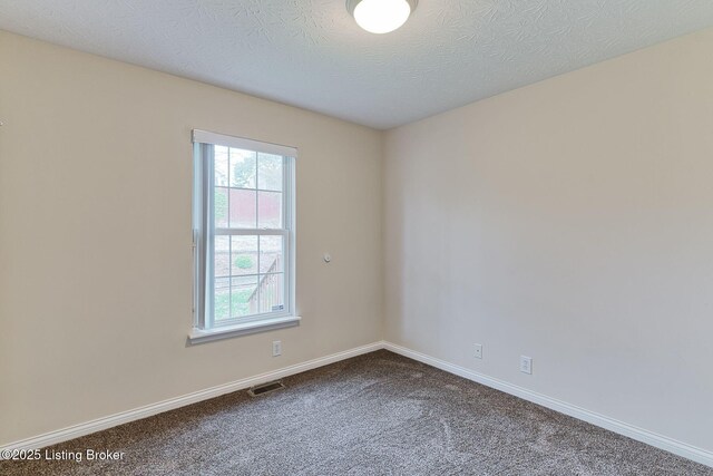 carpeted spare room featuring visible vents and baseboards