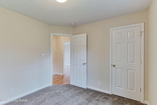 unfurnished bedroom with carpet flooring and baseboards