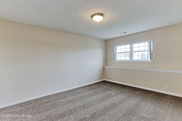 carpeted empty room with baseboards, visible vents, and a textured ceiling