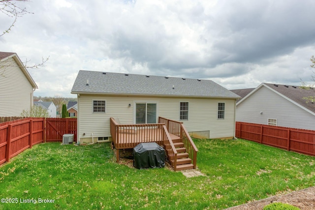 rear view of property with a lawn, roof with shingles, a deck, and a fenced backyard