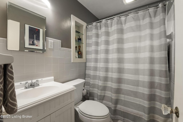 bathroom featuring curtained shower, vanity, tile walls, and toilet